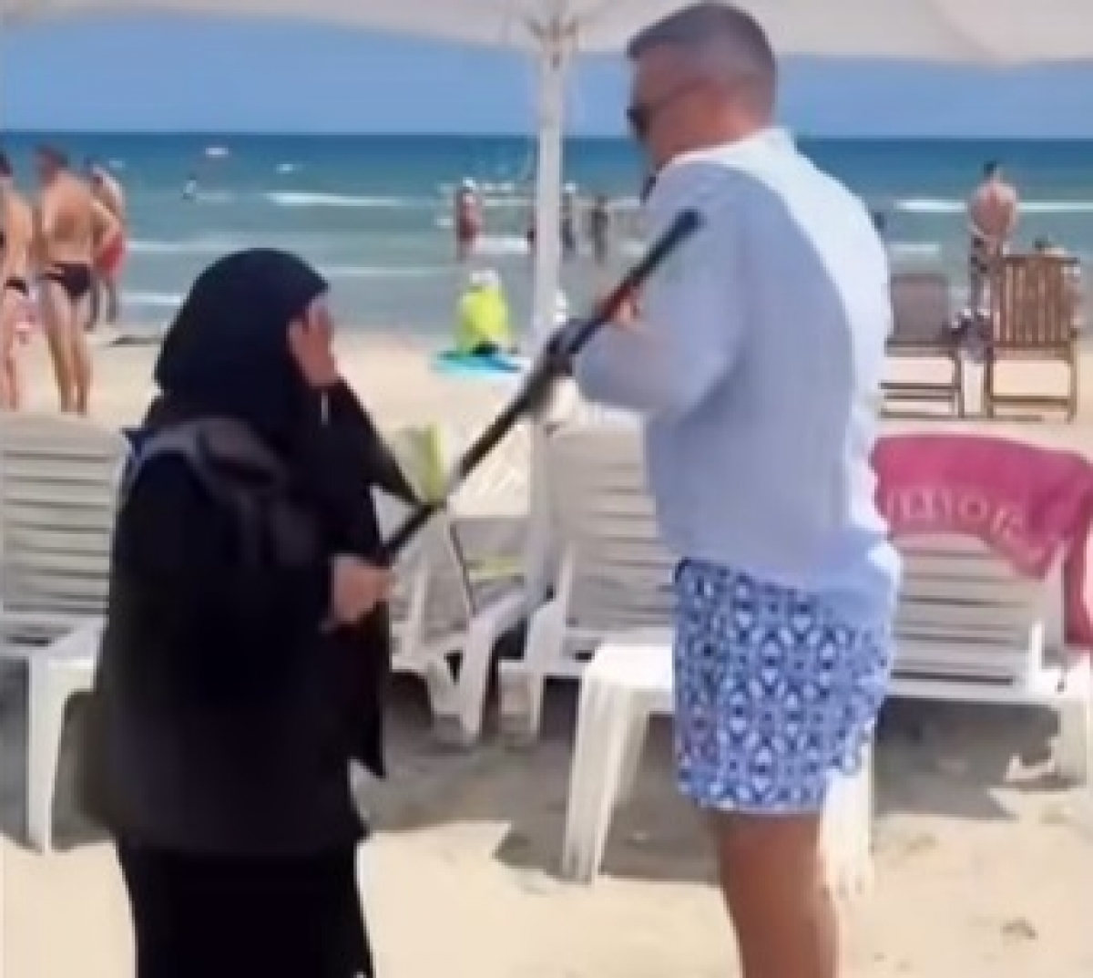 VIDEO Comedie la malul mării, spre deliciul turiștilor: Administratorul unei plaje din Năvodari, fugărit printre prosoape de o bătrânică 'înarmată' cu un baston